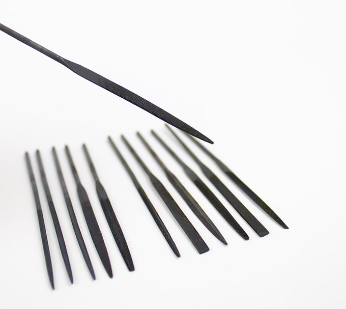 a set of needle files against a white background