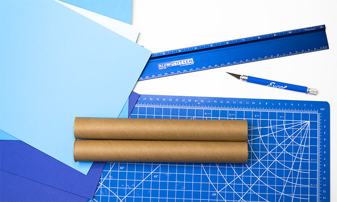 two cardboard tubes on a cutting mat