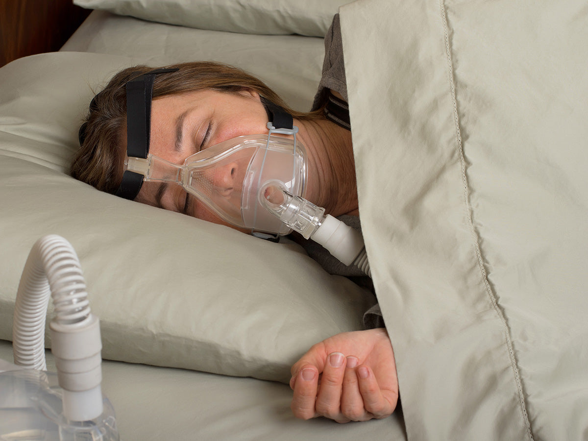 Image of a comfortable woman with a CPAP machine