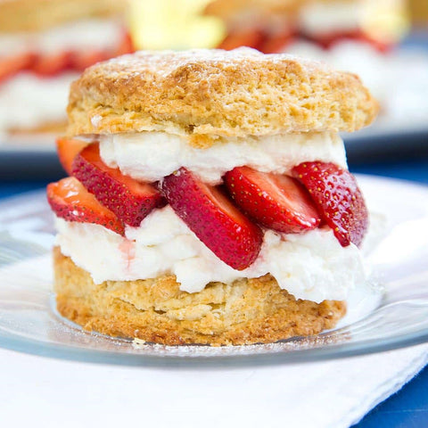 A photo of strawberry shortcake served on a dainty white plate. 
