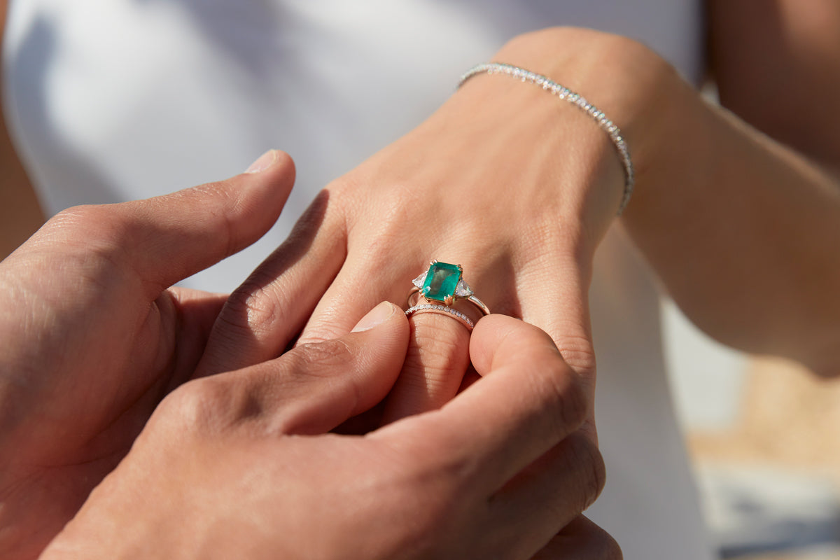 Emerald emerald cut and diamond Trilogy ring with diamond eternity band worn on hand from Fenton