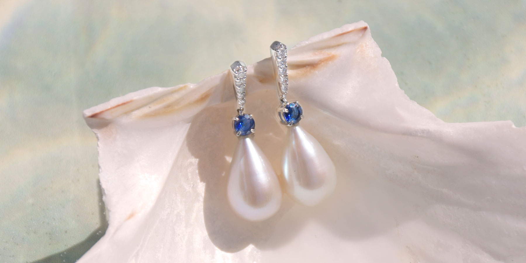 Inspiration de bijoux de mariage avec des boucles d'oreilles en perles classiques et des boucles d'oreilles en pierres précieuses de saphir bleu | Guide des bijoux de mariée avec Fenton