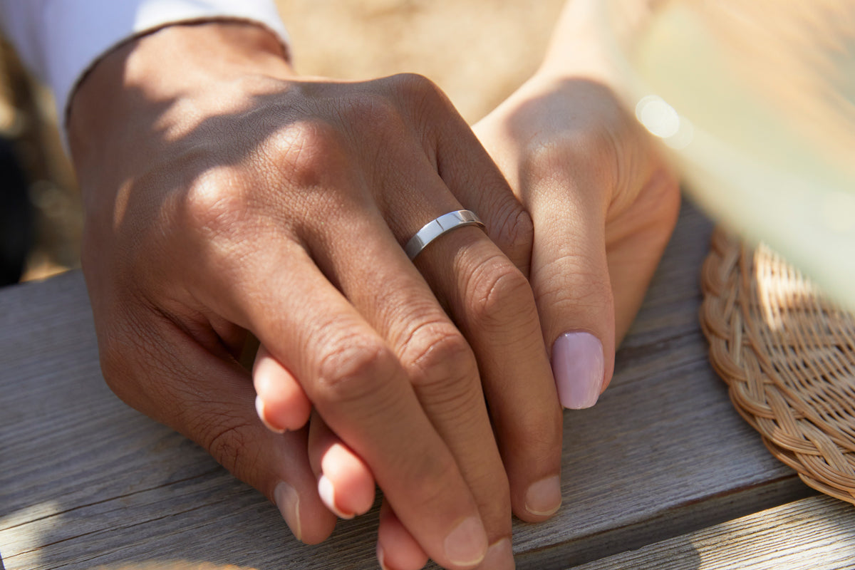 Man wearing Platinum flat wedding band from Fenton holding hands with woman