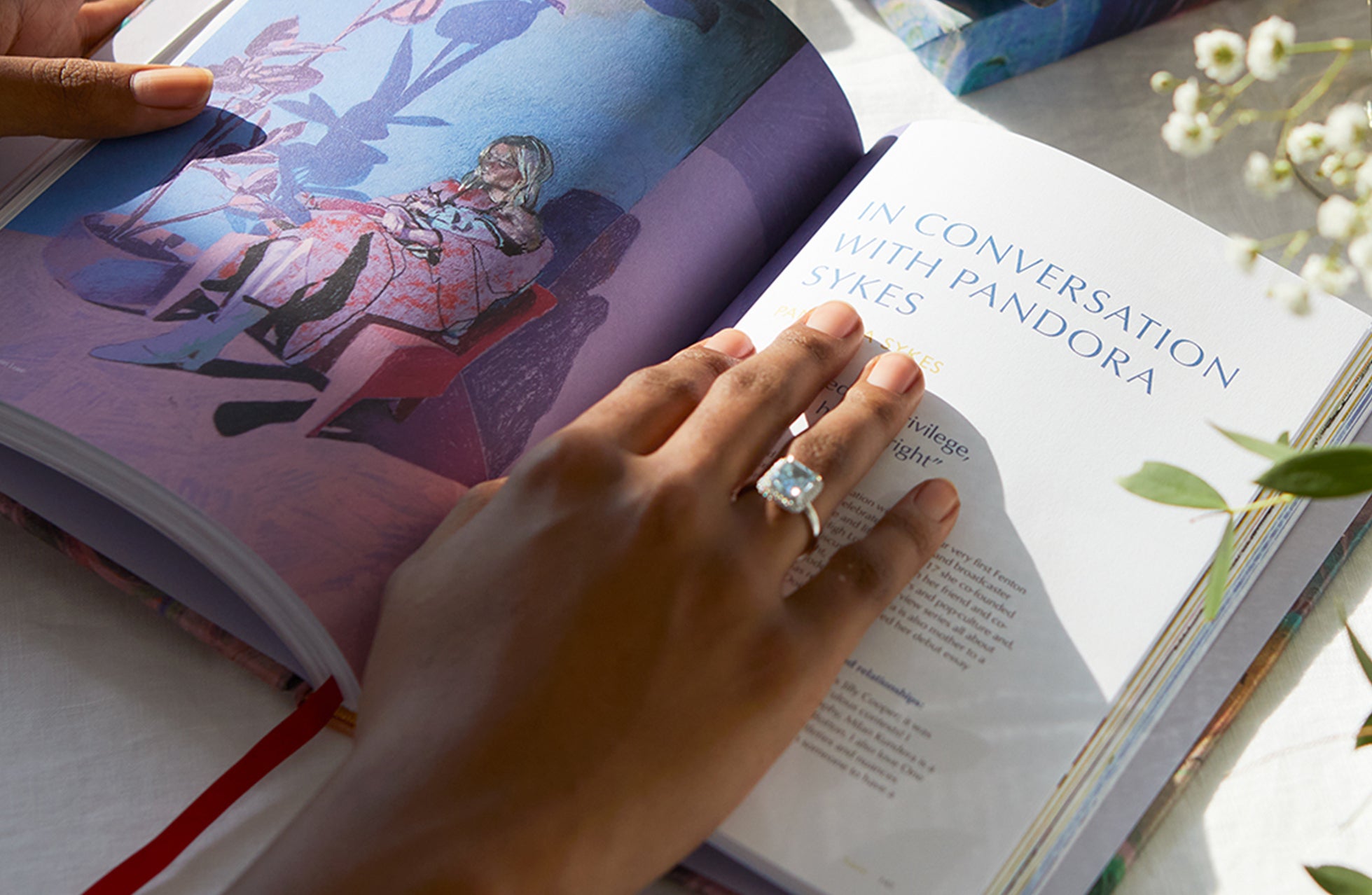 Women wearing aquamarine ring while reading Notes on Love by Fenton 