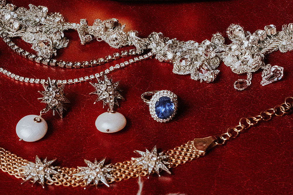 Bague de fiançailles vintage taille ovale en saphir bleu du joaillier fin Fenton sur du velours rouge et d'autres bijoux de mariage