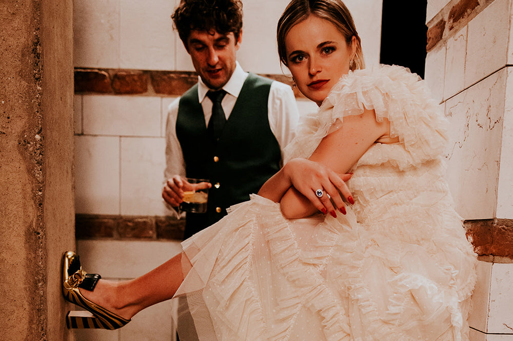 Mariée portant une bague de fiançailles vintage Blue Sapphire avec le marié lors d'une séance photo de mariage