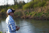 Man in blue flannel outdoor apparel fishing
