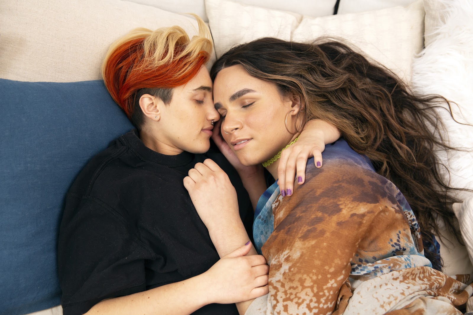 nonbinary couple cuddling in bed