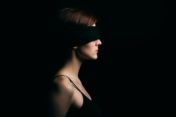 Woman blindfolded - blindfolding and sound isolation headphones are examples of sensory deprivation