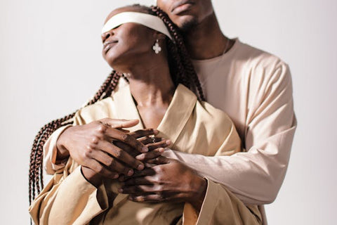 couple embracing each other with one wearing a blindfold