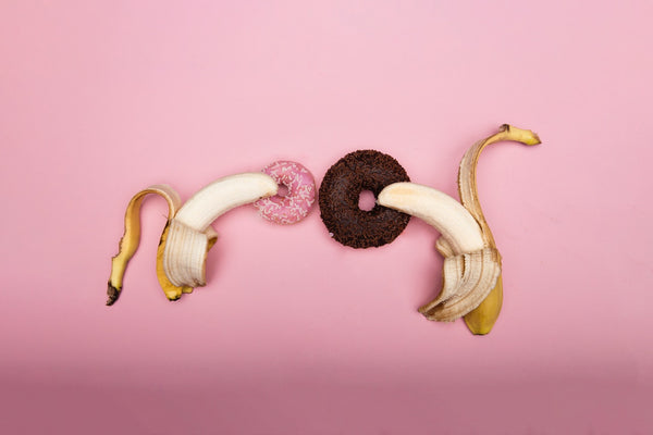 two bananas next to two donuts