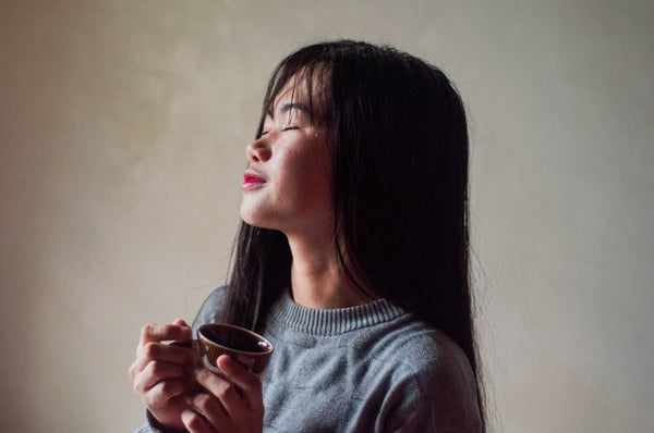 asian woman breathing while drinking tea