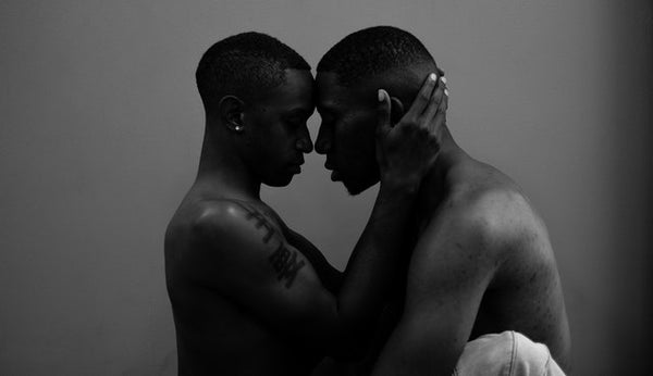 two people of color embracing sensually