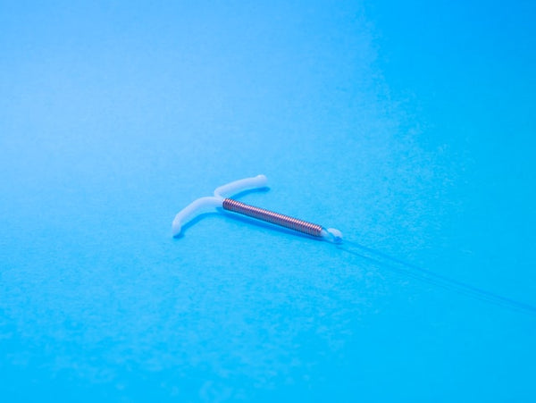 IUD with coil on blue background