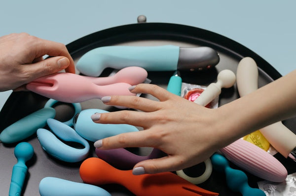 hands picking vibrators from pile 