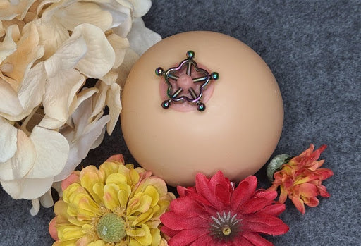 nipple clam on fake breast surrounded with flowers