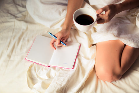 woman on bed with journal