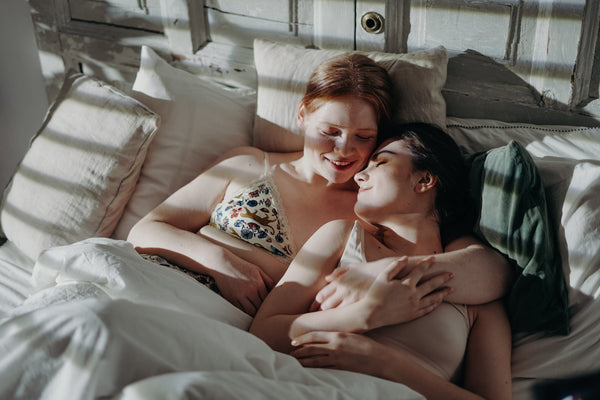 women cuddling in bed