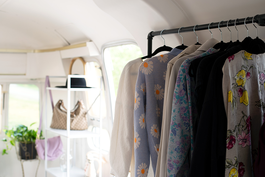 Interior shot of the Airstream Boutique, rack of clothing and shelf with accessories