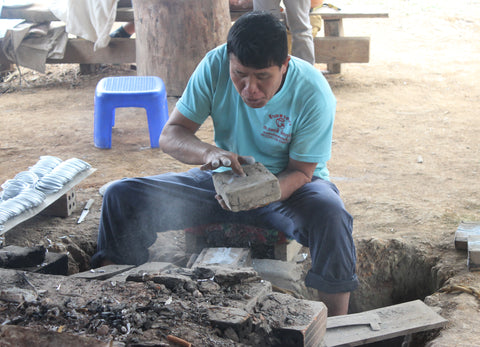 artisan making handicrafts from bombs in Laos