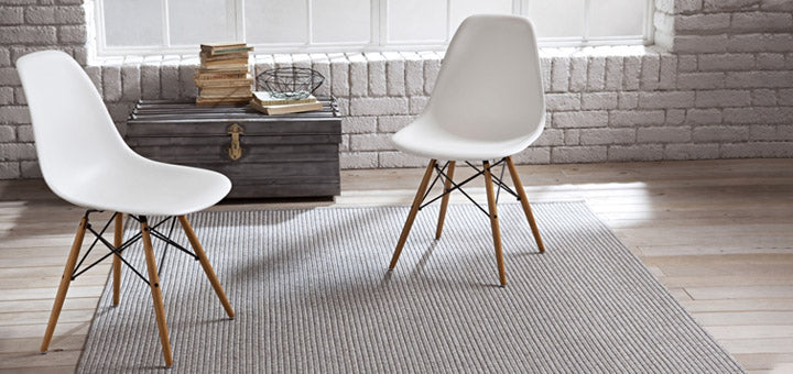 sala de estar con sillas blancas y alfombra gris