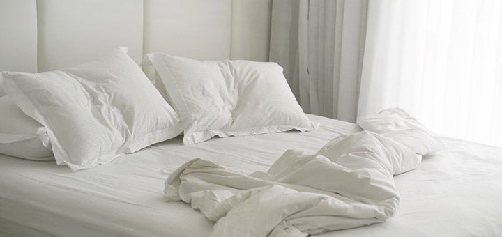 almohadas blancas sobre cama destendida