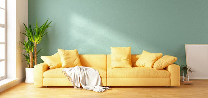 pared de sala de estar de color verde y sofá amarillo