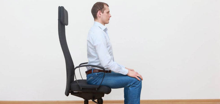 hombre sentado con la espalda recta sobre una silla ergonómica
