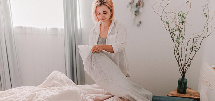 mujer cambiando la funda de su almohada