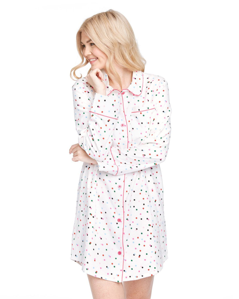 Woman in a long sleeve button down pajama shirt with allover multi-color polka dot print.