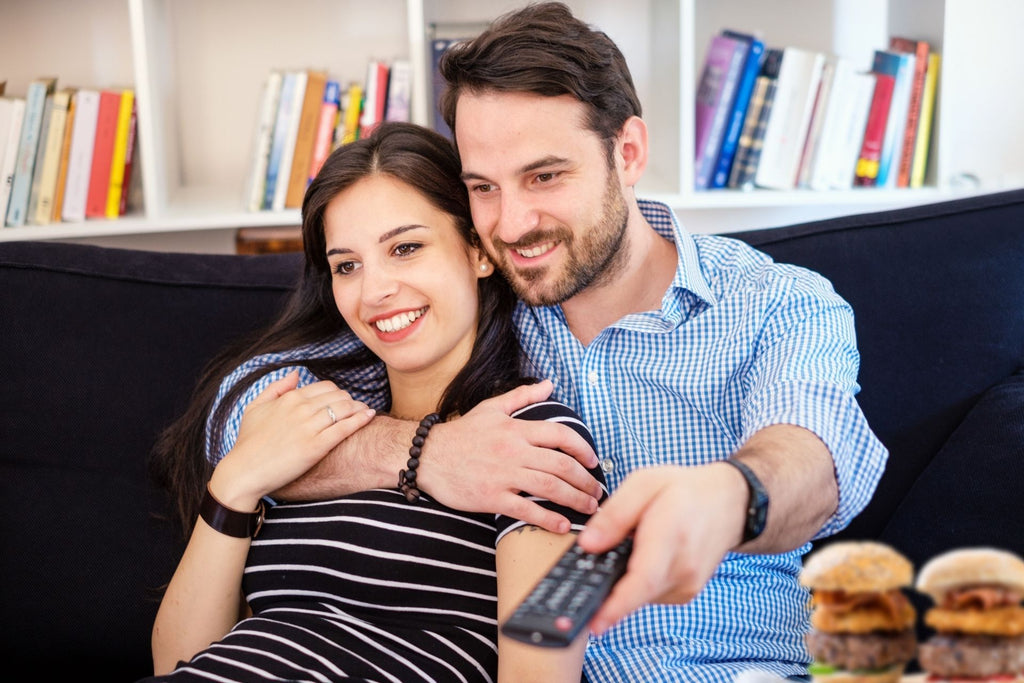 man and woman as a couple watching movie with sliders as snacks