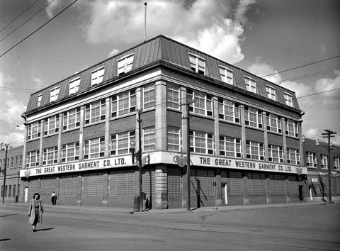 Black and white photo of the Great Western Garment Company, a three-storey historical building shot from ground level with a big Alberta sky behind it.