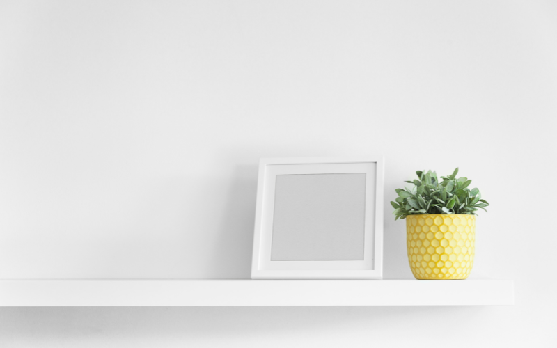 empty picture frame on a floating shelf