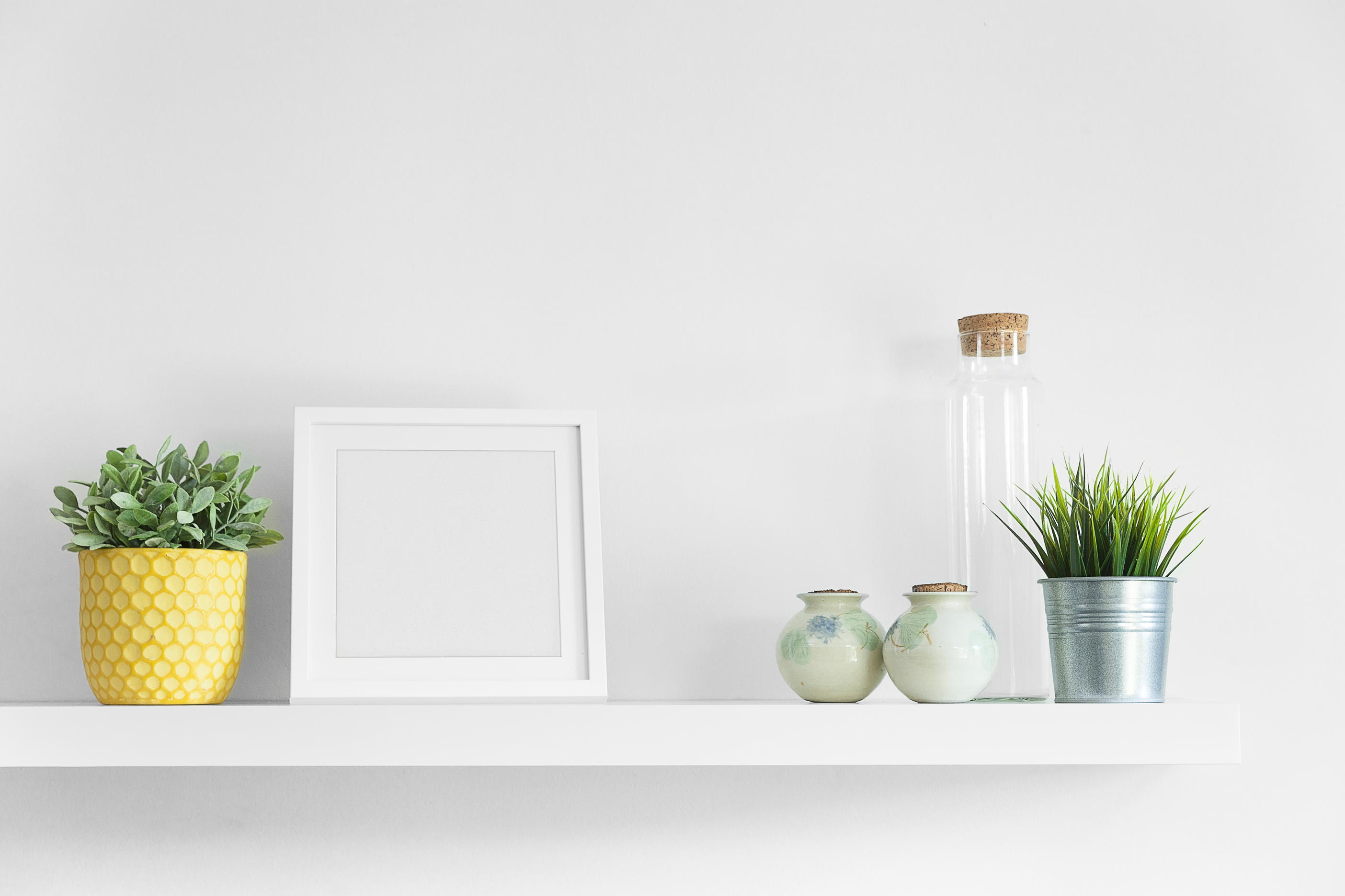 empty picture frame on a floating shelf