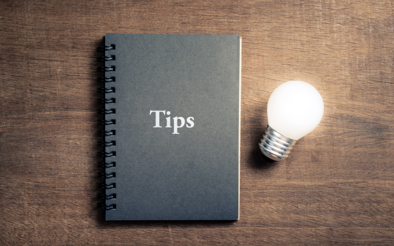 tips written in a notebook beside a lightbulb