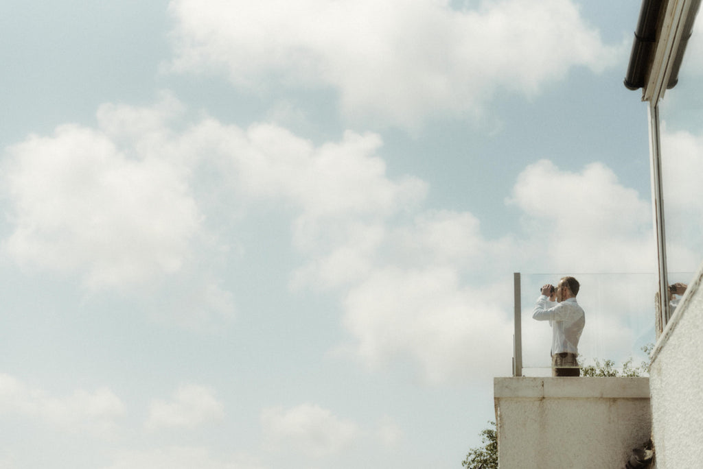 groom with binoculars blue sky