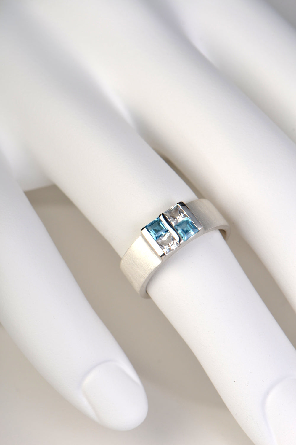 ring on hand with blue and white gemstones