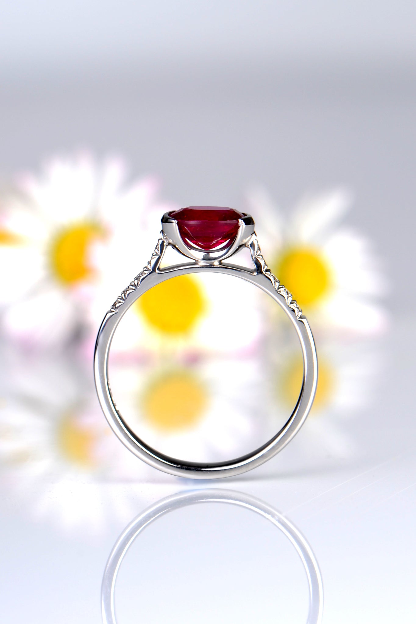 modern oval cut ruby ring with open setting and diamonds in the shoulders