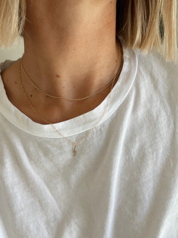 simple minimal gold layered jewelry on white tee