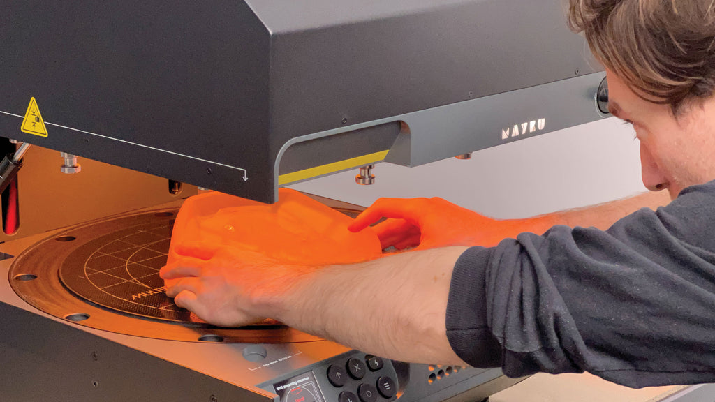 User placing an item to be formed with, onto the Mayku Multiplier forming chamber