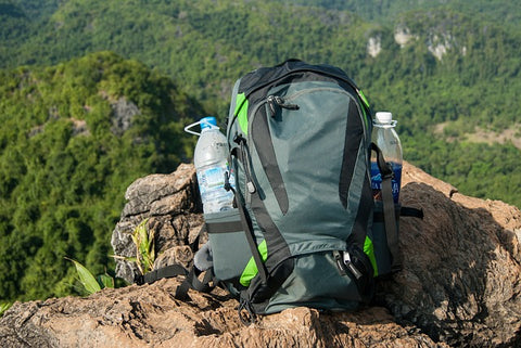 green hiking backpack on the cliff