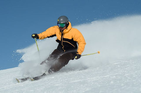 hombre con chaqueta amarilla esquiando