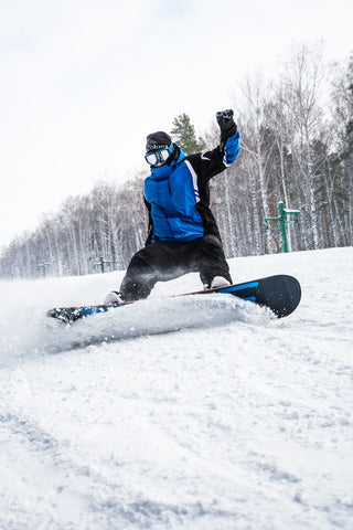 Snowboarder in blauer Jacke und schwarzer Hose