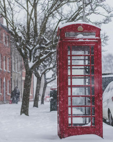 Cabine téléphonique rouge sur sol couvert de neige