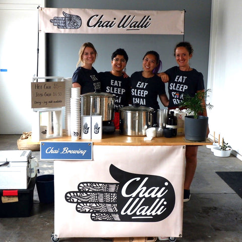 Chai Walli female team mates standing behind the wooden bar.