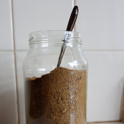 Large glass jar of traditional Indian garam masala mix