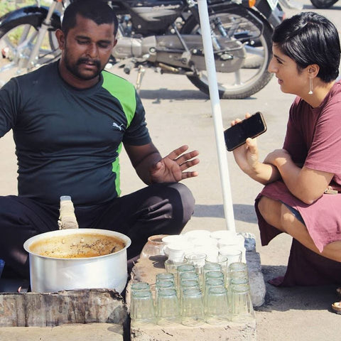 man and woman talking while sitting at a tea stand in India