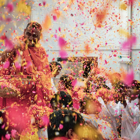 Pink and yellow powders being thrown into the air for Holi Festival.
