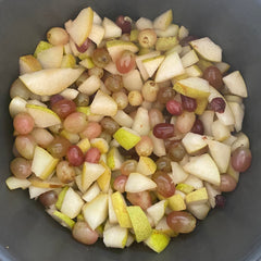 pears and grapes cut up in a pot ready to be made into jam