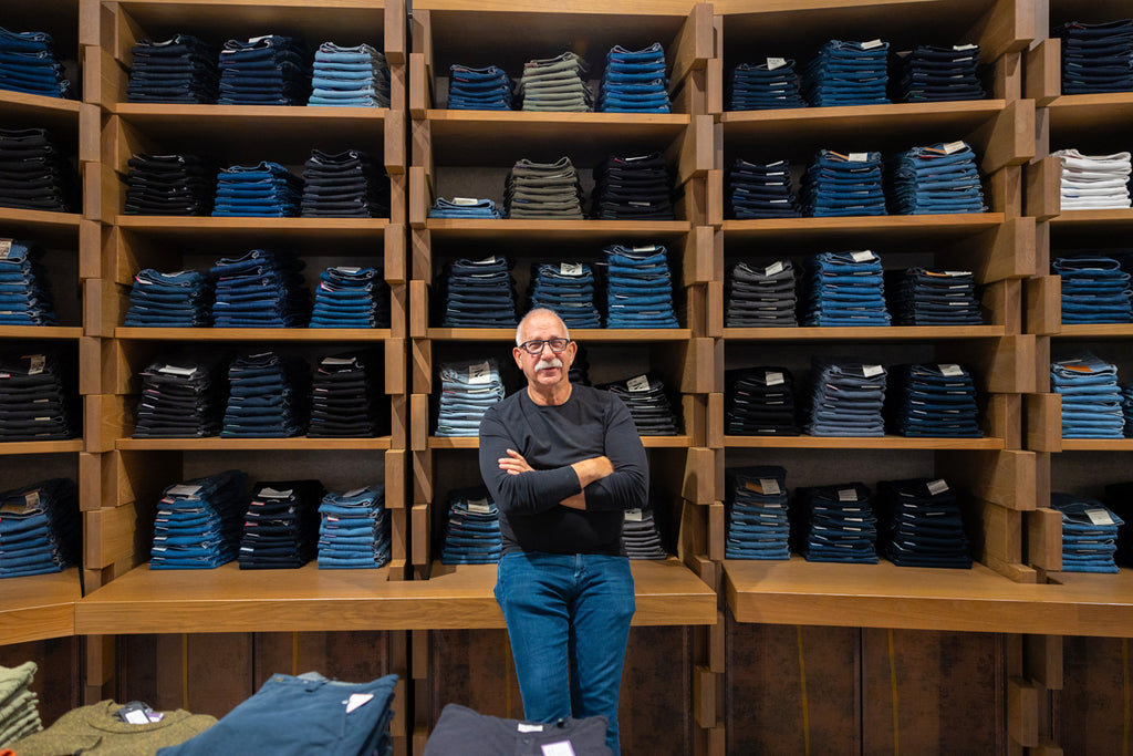 Joel Carman in front of the Over The Rainbow Denim Wall